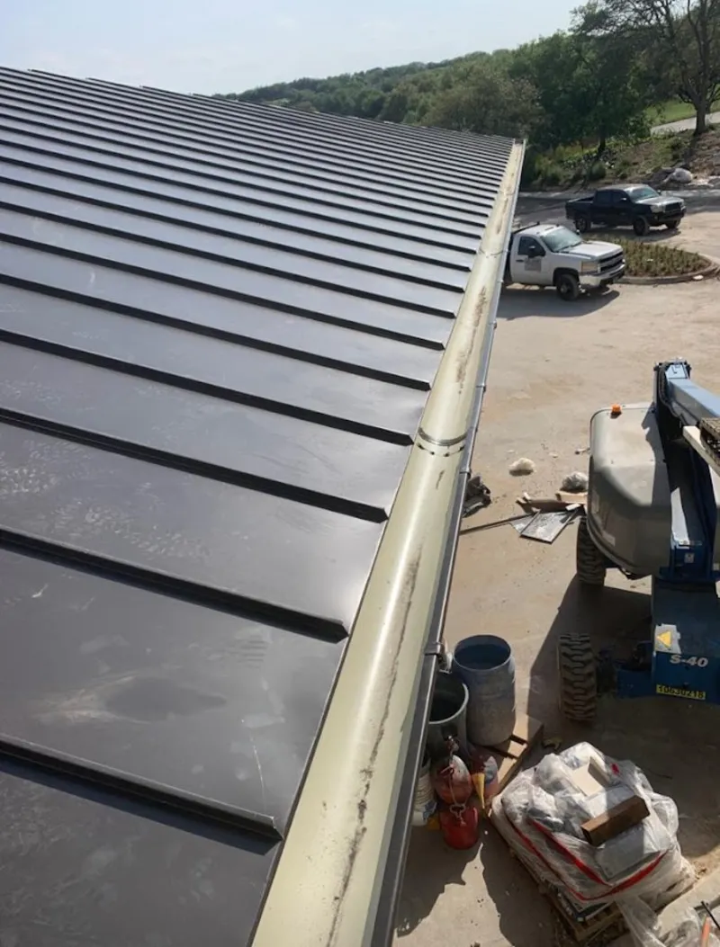 Standing seam panel and gutter detail on a metal roofing jobsite in Marion